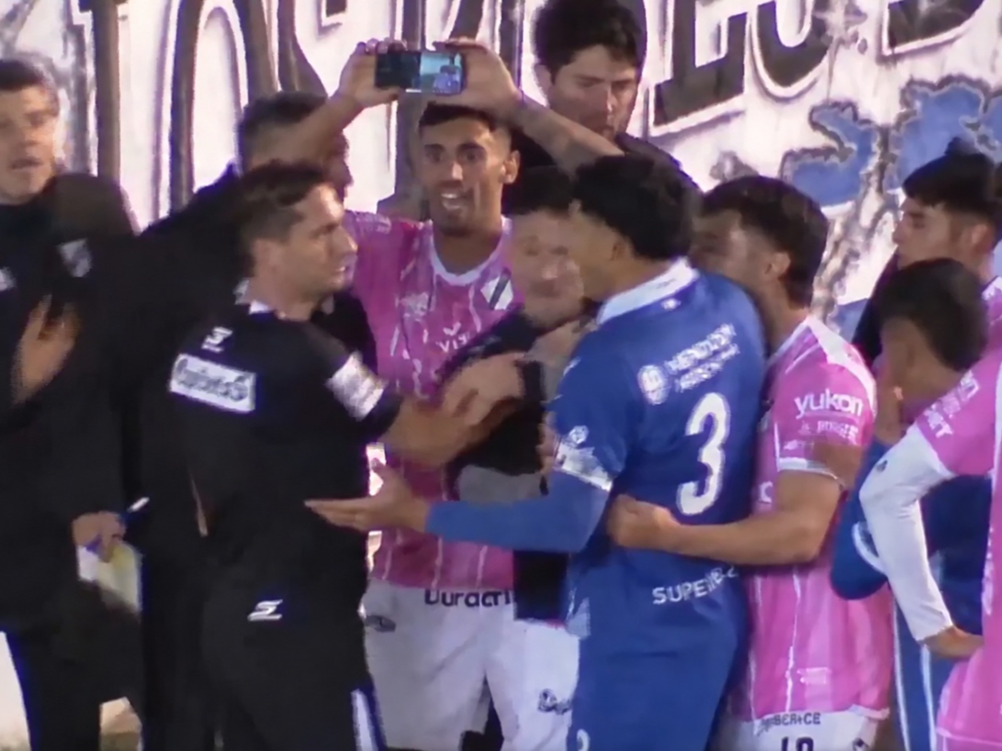 Iván Zafarana intenta mostrarle un teléfono móvil al árbitro Nicolás Lamolina durante el partido entre All Boys y Godoy Cruz en Floresta